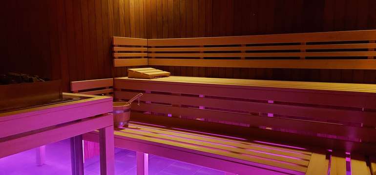 Fínska sauna dvojstupňová. Zdrojom tepla je elektrická pec s košom na lávové kamene.
