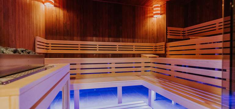 Fínska sauna dvojstupňová. Zdrojom tepla je elektrická pec s košom na lávové kamene.