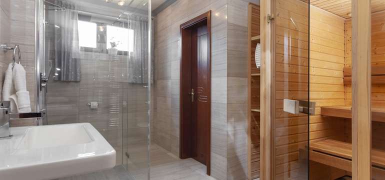 Plně vybavená kuchyňka, jídelní kout, obývací část s krbem a finská sauna