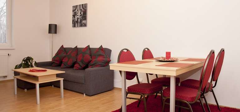 V priestrannej izbe každého apartmánu je jedálenský stôl a stoličky pre 4 až 6 osôb
