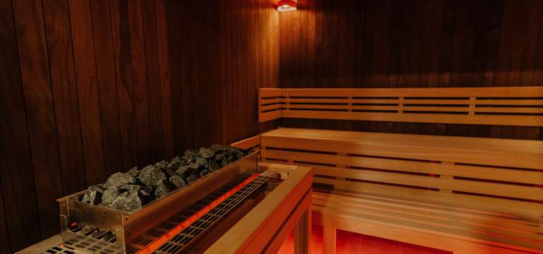 Fínska sauna dvojstupňová. Zdrojom tepla je elektrická pec s košom na lávové kamene.