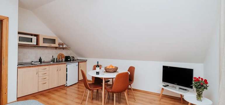 Podkrovný apartmán v depandance s kuchynkou a jedálenským stolom