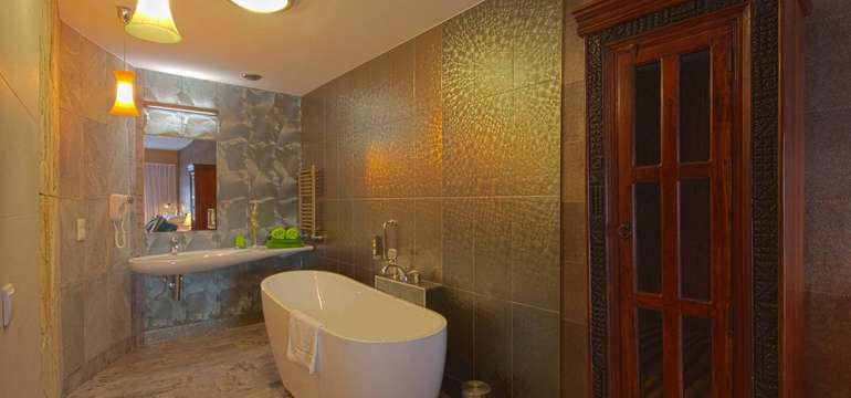 Zelený apartmán s přírodním dřevěným vybavením a originálními designovými doplňky