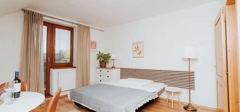 Spálňa apartmánu v depandance s balkónovými dverami a stolíkom