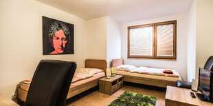 Fotografie s motívmi pop artu navodia tú spravú atmosféru v izbe.