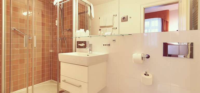 Kúpeľňa dvojlôžkovej izby s fénom a vaňou alebo sprchovacím kútom