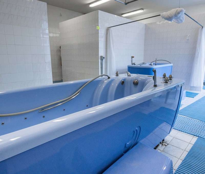 Klientovi ponorenému vo vani je podaná masáž prúdom vody cez masážne trysky vane