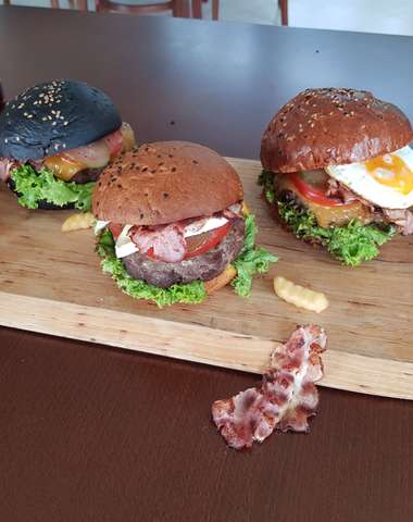Chutný burger s hranolkami a cibuľovými krúžkami (ilustračný obrázok)
