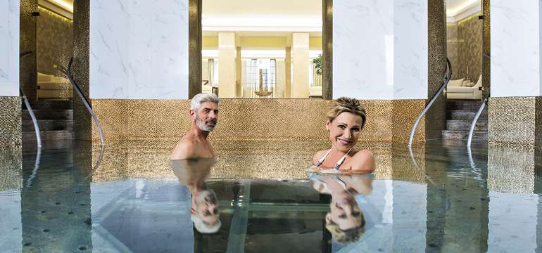 Bazén kruhového tvaru so zlatou mozaikou má stále aktívnu piscinu