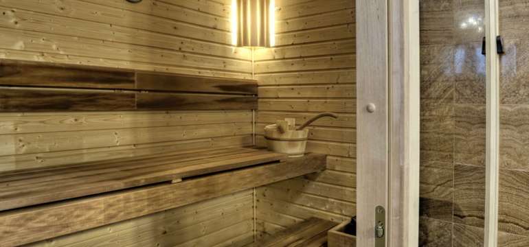 Plně vybavená kuchyňka, jídelní kout, obývací část s krbem a finská sauna