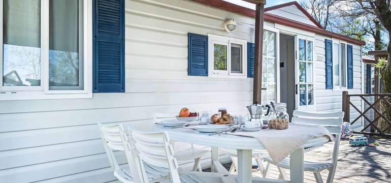 Mobilný domček vo Villaggio San Francesco a jeho terasa s posedením pre chvíle oddychu